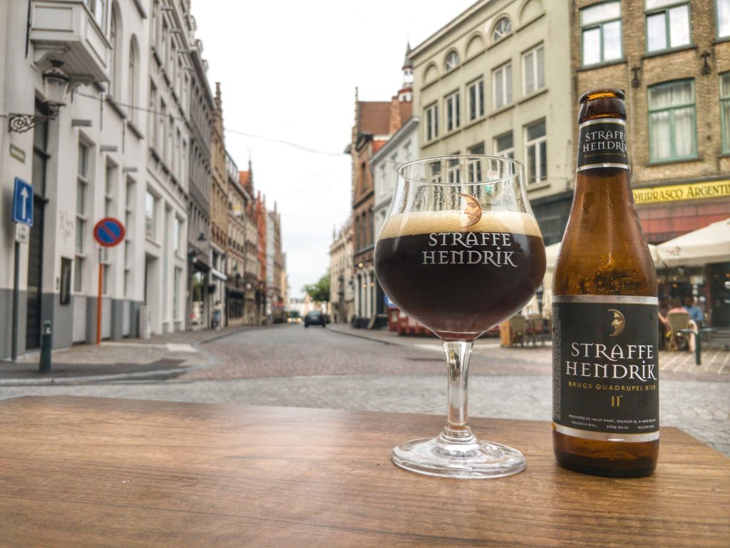 A Straffe Hendrik Quadrupel beer poured into its matching glass in the streets of Bruges