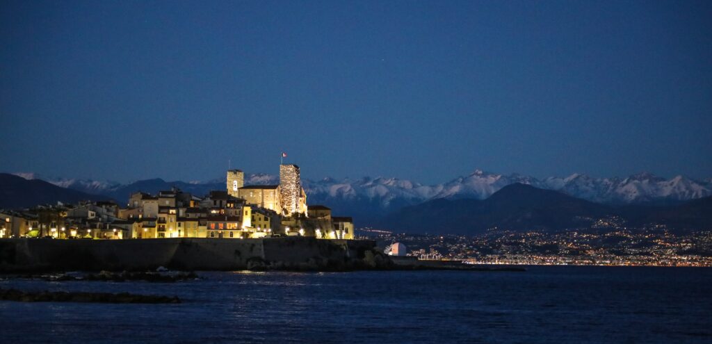 antibes at night with the snowy alps in the back